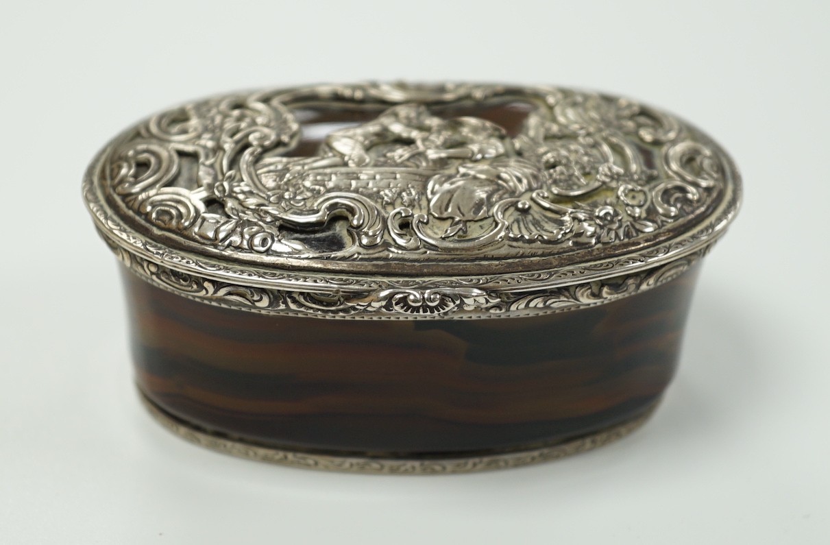 A 19th century continental white metal mounted banded agate oval snuff box, decorated with figures amid scrolls, length 79mm.